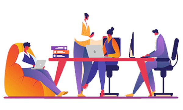 Team collaborating at a table with laptops and desktops