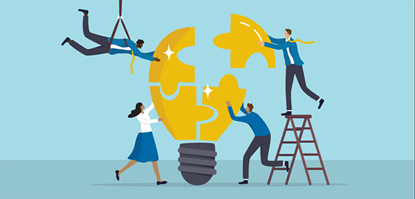 A team assembling a puzzle-like light bulb together